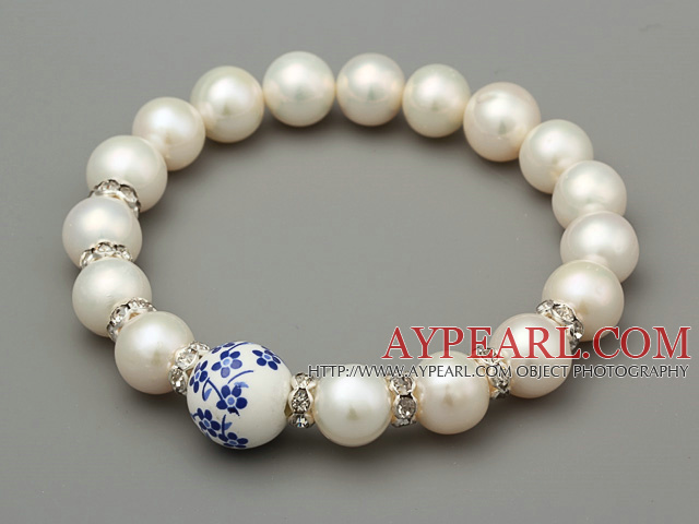 Elegant A Grade Natural White Freshwater Pearl och snidade blomma Porslin boll armband med Rhinestone Charm
