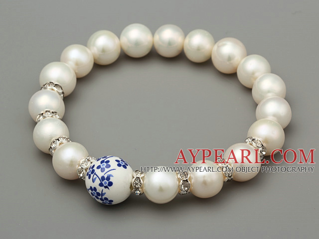 Elegant A Grade Natural White Süßwasser-Zuchtperlen und geschnitzte Blume Porzellan- Kugel-Armband mit Strass Charm