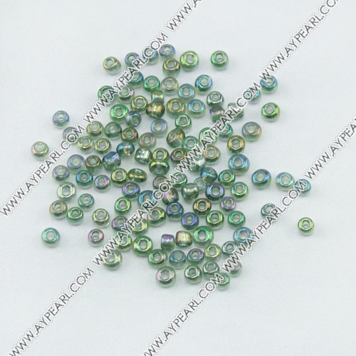 Glass seed beads, transparent rainbow green, 2.5mm round. Sold per pkg of 450 grams.