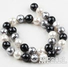 Sea shell beads, black, 12mm faceted round. Sold per 15.16-inch strand.